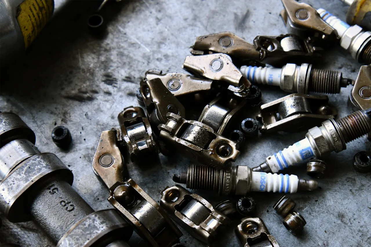 Zdemontowane elementy mechanizmu zaworowego i świece Opla Corsy D