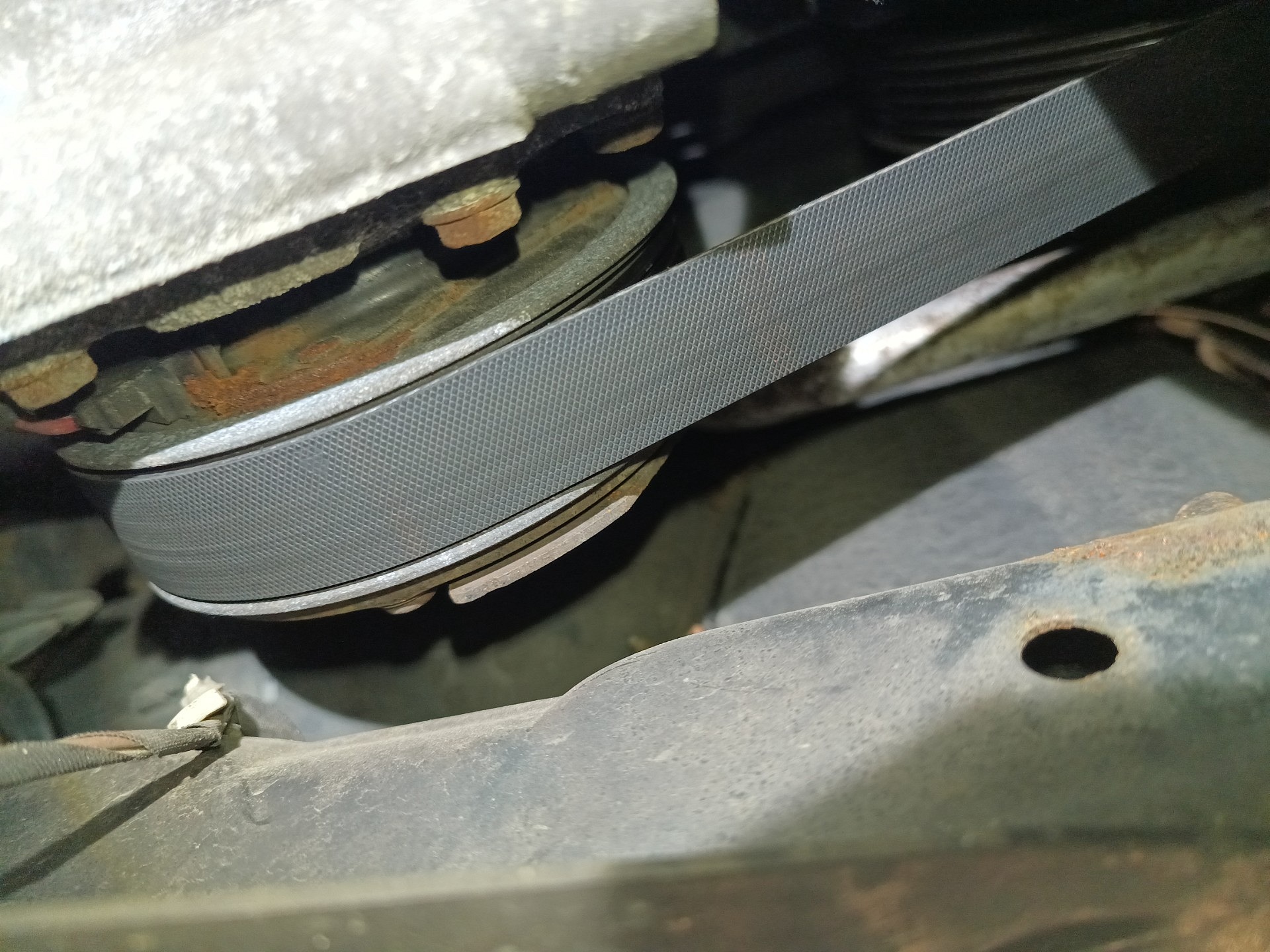 Zbliżenie paska napędowego na kole pasowym z brunatnym nalotem na metalowych częściach — MINI COUNTRYMAN
